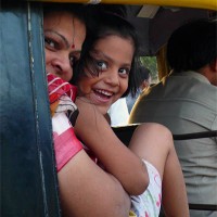 Mother and daughter riding in an Auto Rickshaw in Jalgaon, India. An Auto Rickshaw is a motorized three wheeled cart and version of a traditional rickshaw for hire