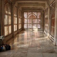 A devotee sits to meditate on the verandah surrounding the mausoleum of the 16th century Sufi saint, Shaikh Salim Chistie. The white marble latticed screens in this tomb are carved form single slabs.