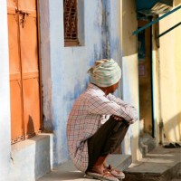 A villager sitting on his front step.